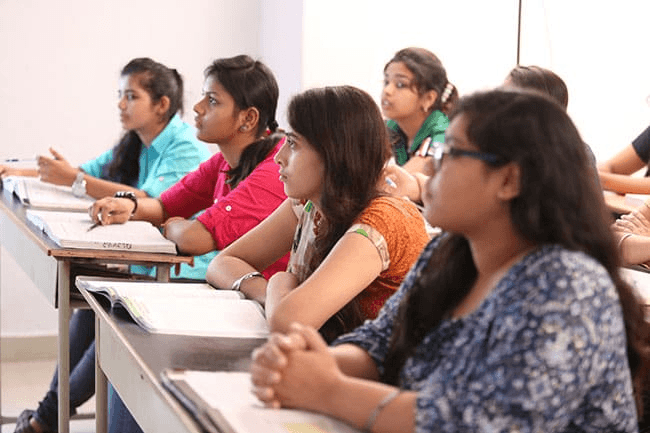 A Narayana classroom in Hyderabad, with students taking notes as the teacher discusses test-taking strategies.